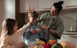 Mother and children have fun unpacking vegetables in the kitchen.